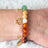 Armband mit Chakra-Steinen und goldenen Chakra-Symbolanhängern